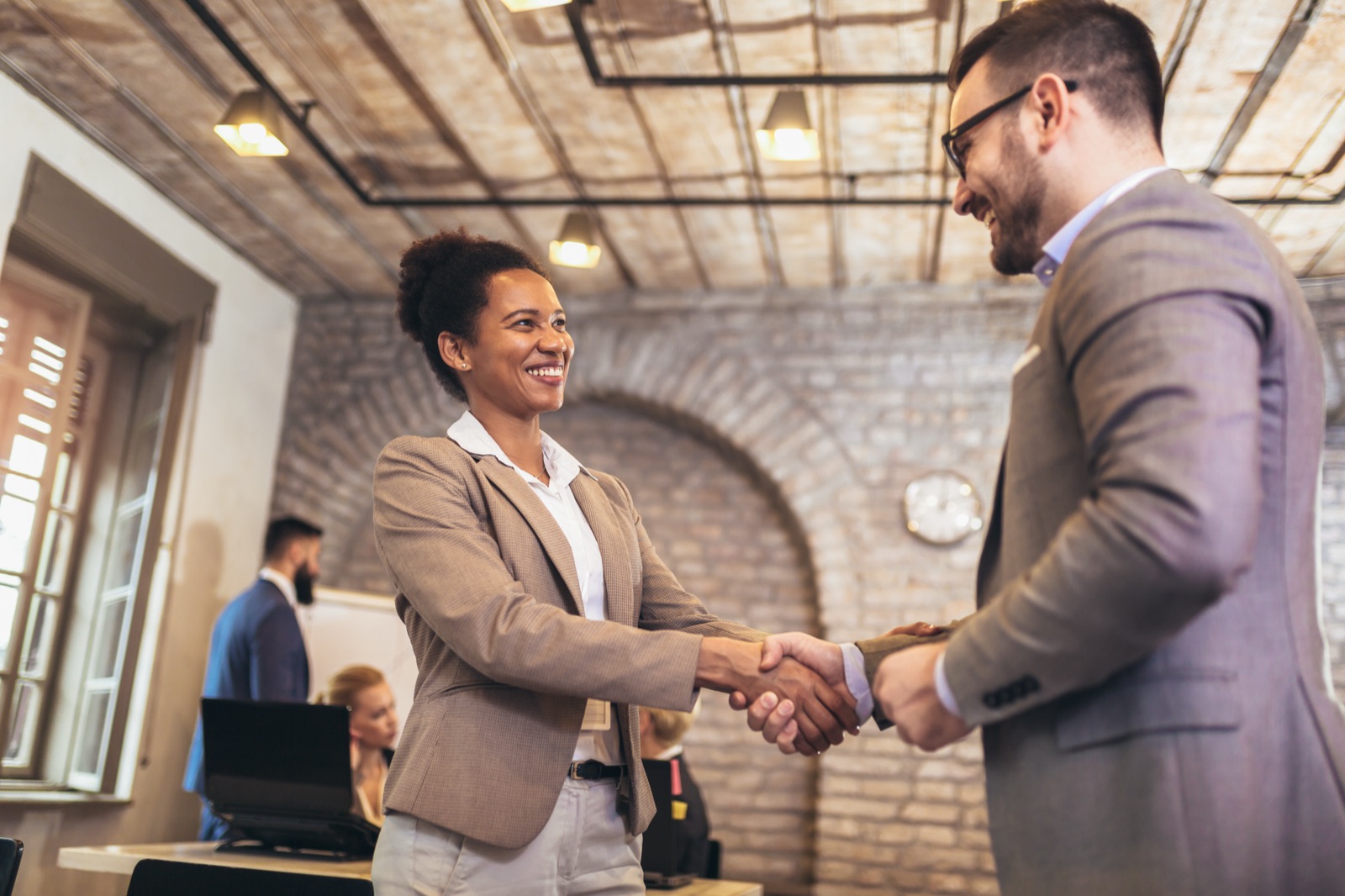 Poignée de main entre un formateur et un client en entreprise