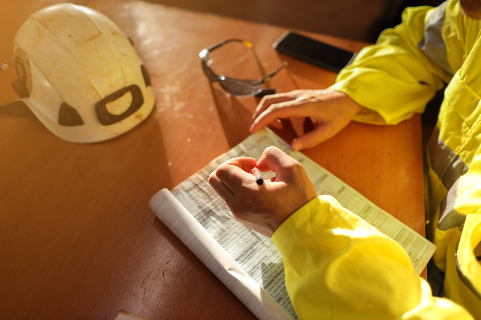 Préventeur en tenue de travail consignant par écrit les faits et les mesures issues de l'analyse d'un accident