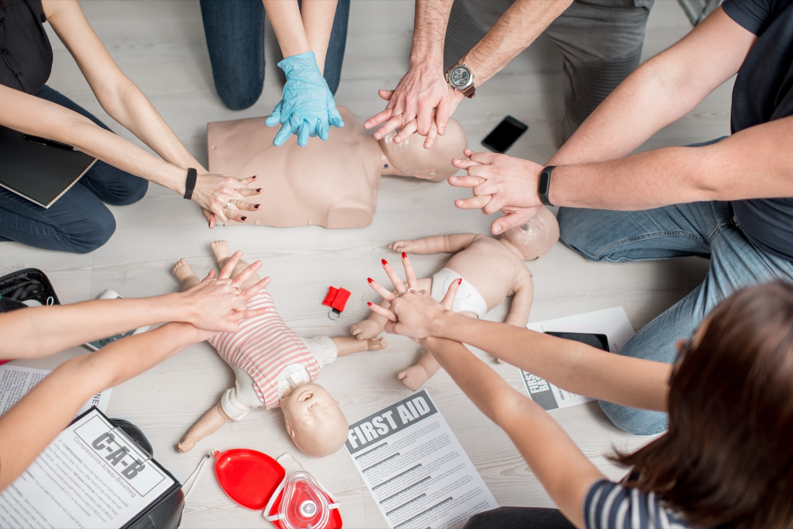 Stagiaires s'exerçant au massage cardiaque sur mannequin en formation SST