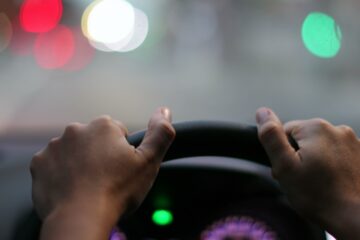 Conducteur professionnel les deux mains sur le volant, véhicule à l'arrêt au feu rouge