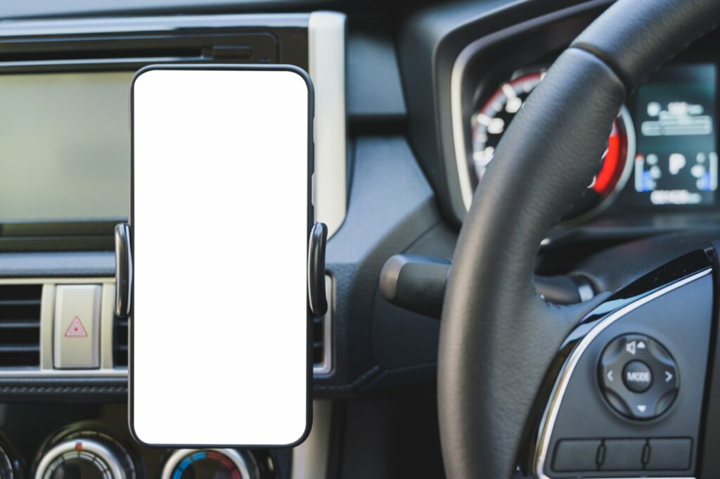 Smartphone fixé sur un support de ventilation dans un véhicule, hors de portée de main du conducteur