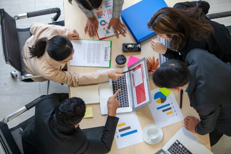Élus analysant ensemble des documents et un ordinateur portable autour d'une table de réunion