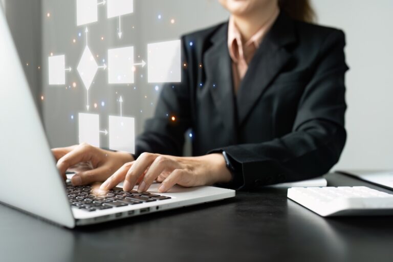 Utilisatrice sur ordinateur portable devant un logigramme d'automatisation des tâches